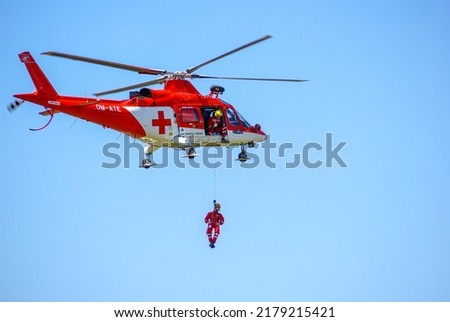 Rescue helicopter at sky with paratrooper Royalty-Free Stock Photo #2179215421