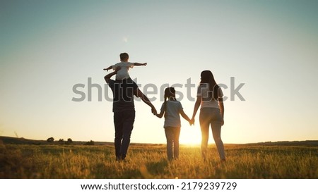 Happy family walk in field in nature.Parents and children are free and active people in nature.Healthy and cheerful family at picnic in the park.Summer walk in the park at sunset.Parents and children Royalty-Free Stock Photo #2179239729