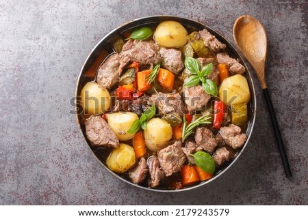 Traditional croatian dish Peka view, meat and vegetables in iron cover under warm glow close-up on the table. horizontal top view from above
 Royalty-Free Stock Photo #2179243579