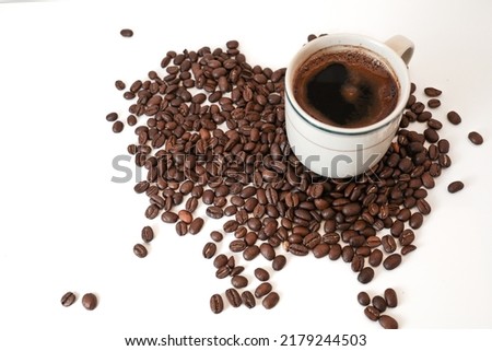 coffee beans on a white background with a cup of black coffee
