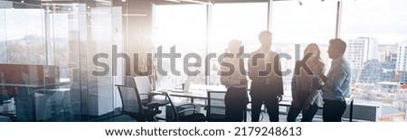 Business team standing against panoramic windows in modern office. Blurred background Royalty-Free Stock Photo #2179248613