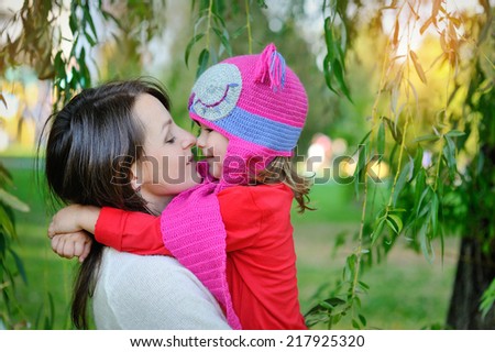 daughter in a knitted cap with his mother in the park