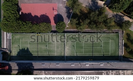 Aerial view of multi-functional sports area with tennis courts, basketball court, and football pitch in Santo Tirso, Portugal.
