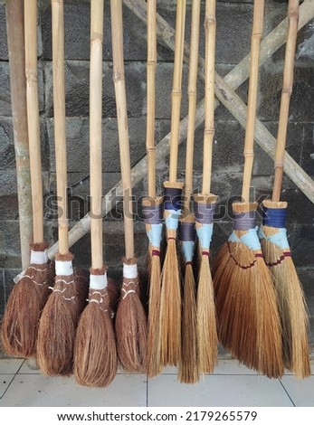 Display of traditional long-handled broom made of coconut fiber and a kind of plant