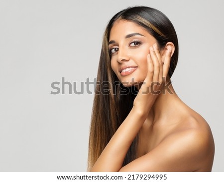 Young Woman Face Portrait. Beauty Model touching Cheekbones. Women Facial Skin Care and Facelift Treatment over White background. Smiling Fashion Girl with smooth Makeup Royalty-Free Stock Photo #2179294995