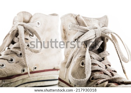 Detail of shoelaces on grunge white sneakers on white background. Isolated objects.