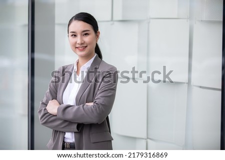 Portrait of the beautiful asian businesswoman with arms crossed on a building background.