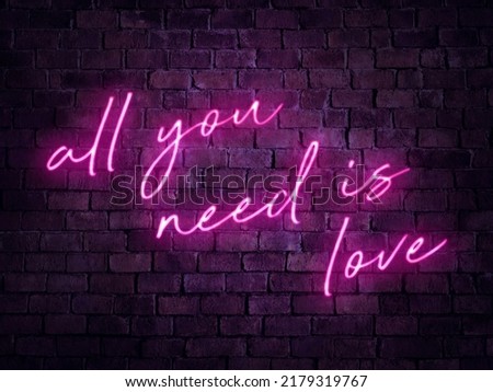 An all you need is love neon sign. Illuminated signage for a bar, pub or tavern.