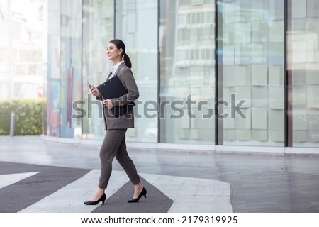 Asian business photo of beautiful girl in casual suite with smart phone,
asian woman with smartphone walking against street blurred building background.