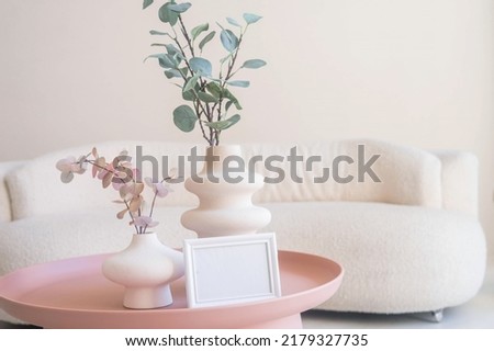 Portrait white picture frame mockup on table. Modern ceramic vase. Scandinavian interior.  