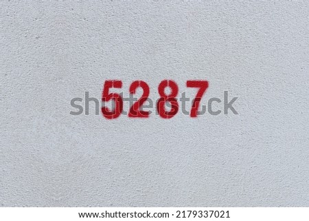Red Number 5287 on the white wall. Spray paint.

