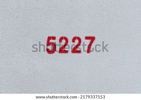 Red Number 5227 on the white wall. Spray paint.

