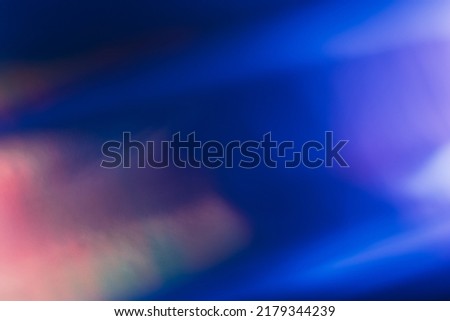 Defocused light leak. Bokeh neon glow. Sci-Fi radiance. Blur fluorescent navy blue orange purple color flecks flare motion on dark futuristic abstract background. Royalty-Free Stock Photo #2179344239