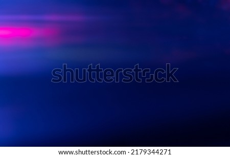 Blur light. Neon glow overlay. Cyber radiance. Defocused ultraviolet navy blue magenta pink color flecks flare on dark modern abstract copy space background.