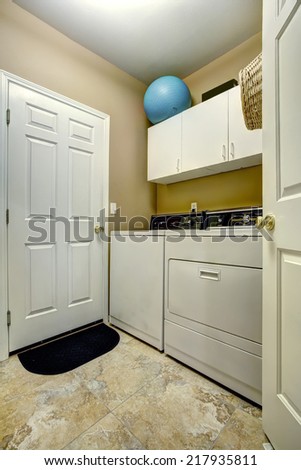 Simple laundry room interior with white cabinets and appliances.