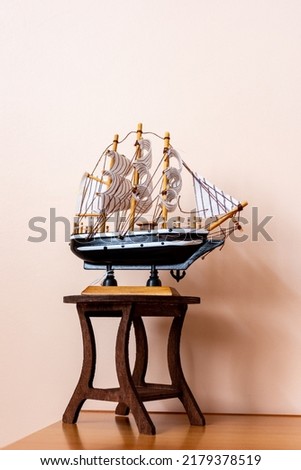 Close up a wooden miniature ship on a small table.