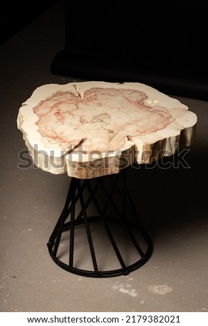 Expensive vintage furniture. Luxury quality wood processing. Exclusive coffee table made of solid wood. Tabletop with live edge and natural cracks. Wooden table on a dark background.