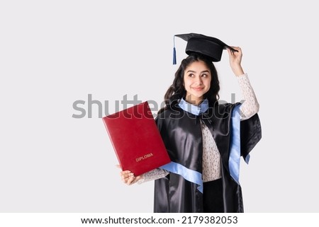 Beautiful indian woman university graduate wearing academic regalia with red diploma mockup isolated on white background. Royalty-Free Stock Photo #2179382053