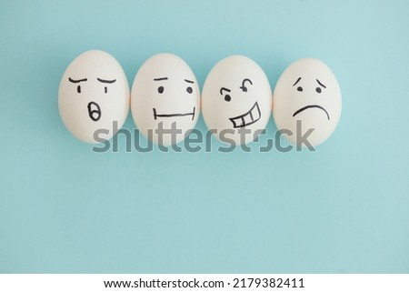 Smiling and sad eggs on a yellow-blue background