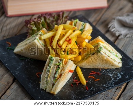 club sandwich with fries isolated on cutting board side view of fastfood on wooden background