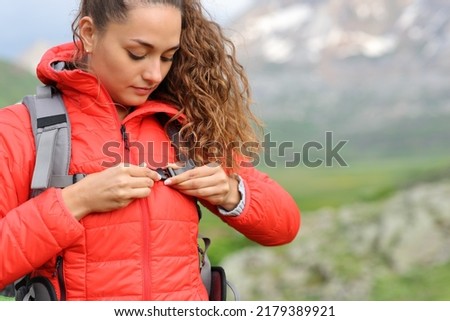 Hiker in red fastening backpack strap in the mountain ready to walk Royalty-Free Stock Photo #2179389921
