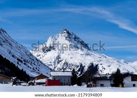 a mountain in Galtür covered in snow, village in foreground