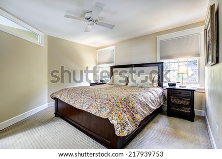 Light ivory bedroom interior with dark brown bed and nightstands