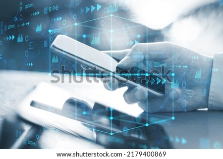 Close up of businessman hands using smartphone with abstract cube hologram on blurry outdoor background. Metaverse, software, future and data center concept. Double exposure Royalty-Free Stock Photo #2179400869