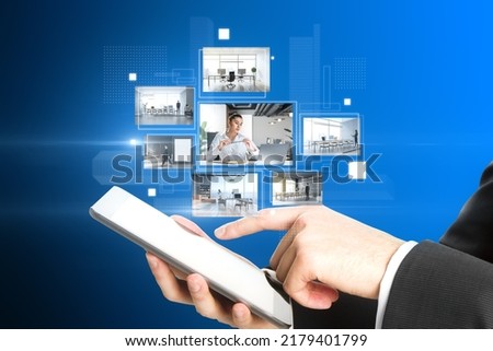 Close up of businessman hand pointing at cellphone with creative digital picture gallery on blue background. Photo album and media technology concept. Switching images