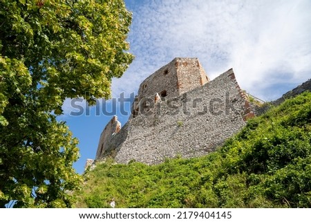 The ruins of Csesznek Castle on a sunny summer day, on the hilltop, with a cloudy sky in the background. Csesznek, Hungary