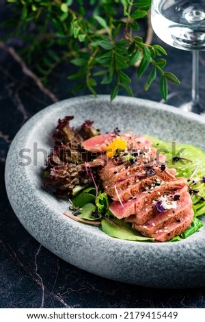 Ahi tuna. Delicious Tuna Sashimi, raw sliced fish on black background. Traditional Japanese cuisine sashimi with tuna and avocado. maguro tataki ponzu Royalty-Free Stock Photo #2179415449