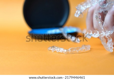 hand hold pile of invisible braces on case background