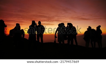 a silhouette of a group of people at sunrise in Bromo  