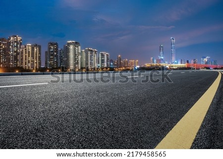 Asphalt road and city skyline with modern building at night in Suzhou, China. 