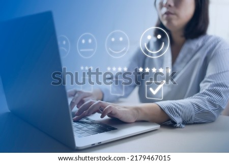 Satisfaction and customer service survey concept, business people using  laptop. to answer the questionnaire And the satisfaction rating, the satisfaction rating with the smiley face icon 5 stars.