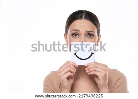 Unhappy young woman with smile, drawn on sheet of paper on a white studio background.