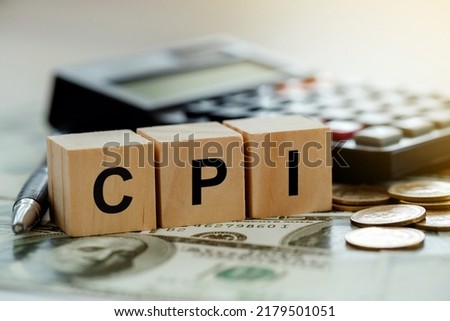 CPI, consumer price index symbol. Wooden blocks with words CPI, consumer price index on dollar bills with a calculator, coins.  Business and CPI, Business and consumer price index concept. Royalty-Free Stock Photo #2179501051
