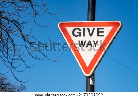 A give-way sign set against a blue sky