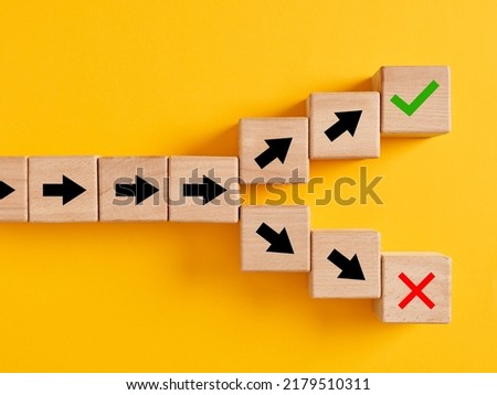 Arrow symbols on wooden cubes splitting into different directions towards right or wrong choices. Following the right or wrong path or choosing the right or wrong way. Royalty-Free Stock Photo #2179510311