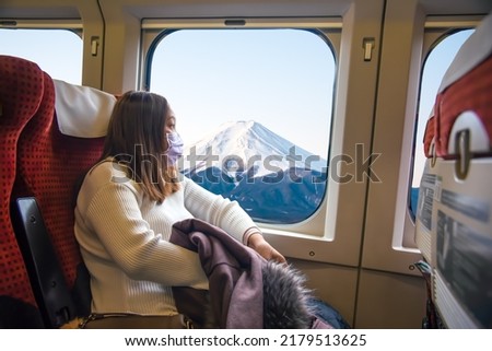 Yong Asian woman sitting in the high-speed train while traveling in Japan. Royalty-Free Stock Photo #2179513625