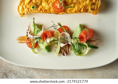 Omelet with avocado mousse and salmon in a plate. Selective Focus. Noise in post-production