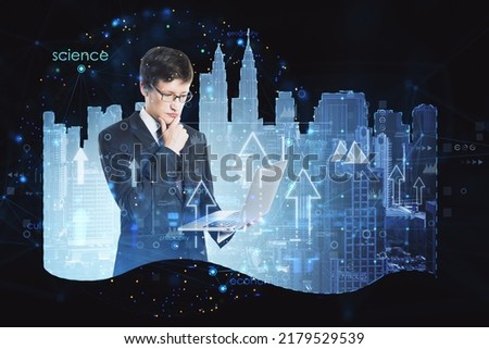 Attractive thoughtful young european businessman with laptop and abstract city hologram, arrows and business chart. Smart city and future concept. Double exposure