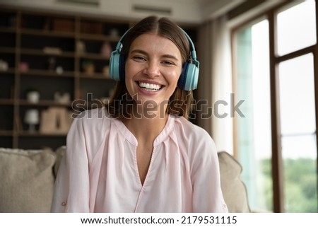 Head shot portrait woman in headphones take part in on-line stream, vlogger record video, enjoy remote conversation via videoconference to family or friend. Modern technology, communication concept Royalty-Free Stock Photo #2179531115