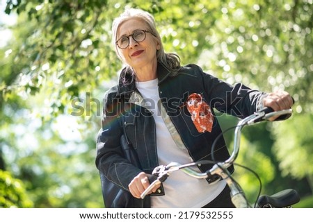 Mid aged woman with a bike in the park