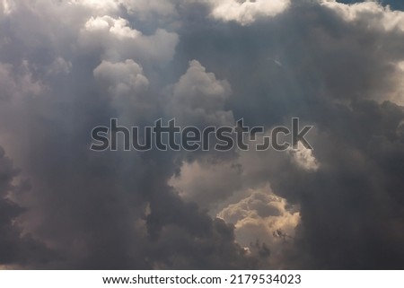 Summer cloudy dramatic rainy sky background with sun rays. Panoramic view with beautiful clouds. Horizontal cloudscape. High-resolution photography. Design element. Copy space. 