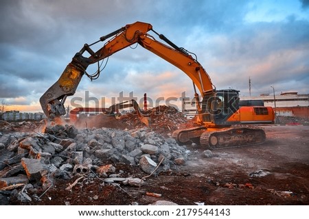 Excavator with concrete crusher on rig at demolition site Royalty-Free Stock Photo #2179544143