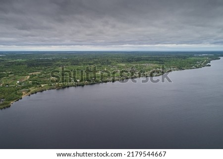 Top view of the lake and the shore of the earth, the skyline of the sky on a cloudy day. Beautiful summer landscape, picture from the drone.