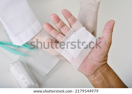 Doctor doing wound dressing care and bandaging patient's hand, Hand surgery treatment, Nurse treat patient's finger injury in hospital. Royalty-Free Stock Photo #2179544979