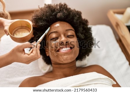 Young african american woman smiling confident having facial treatment at beauty center Royalty-Free Stock Photo #2179560433