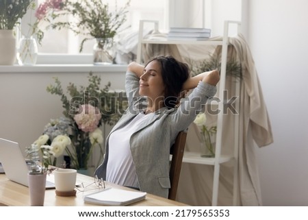 Daydreaming. Calm happy young woman floral arranger decorator relaxing at desk with closed eyes. Manager consultant at flower shop leaning back on chair napping enjoying lazy moment with serene smile Royalty-Free Stock Photo #2179565353